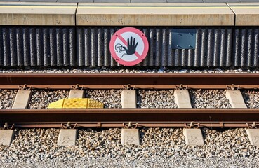 Do not cross, railway tracks and warning sign at station platform