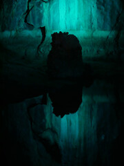magic view of a lake in a cave mirrowing the bright neon light and a stone silhouette