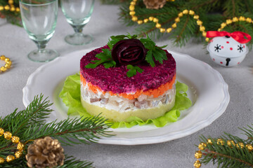 Holiday salad Herring under fur coat on white plate, decorated with rose from beets