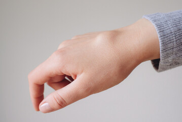 Female right back hand with ganglion cyst on the dorsum,  fluid-filled bump associated with a joint or tendon sheath, close-up view, selected focus.