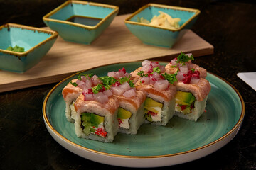 A Plate of Exquisite Sushi Featuring Unique Ingredients Like Salmon, Avocado, and Wasabi Served with Soy Sauce and Garnishes