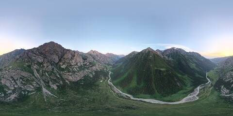 Breathtaking aerial panorama showcasing a winding river flowing through a lush green valley nestled amidst towering, rocky mountains, illuminated by the warm glow of the setting sun