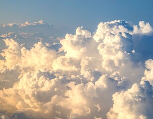 Aerial perspective view of fluffy cumulus clouds illuminated by soft golden light