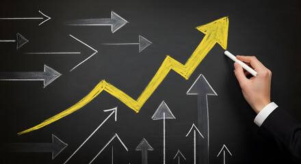 Hand drawing a large yellow upward arrow over smaller gray arrows on a blackboard, symbolizing business growth, strategic direction, and success.