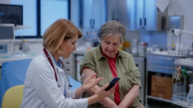Endocrinologist teaching older patient how to connect continuous glucose monitor with mobil app.