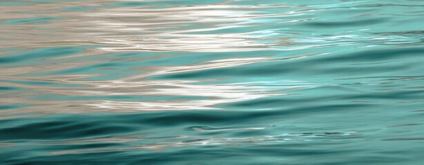 The tranquil water surface reflecting soft hues and gentle waves.