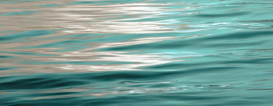 The tranquil water surface reflecting soft hues and gentle waves.