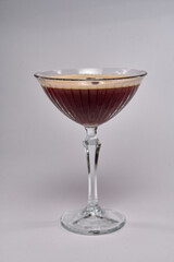 A stunning cocktail presented in an elegant glass showcasing rich dark hues and a creamy foam layer, perfect for any sophisticated gathering or celebration.