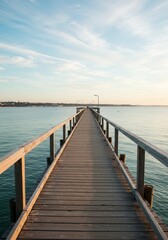 Fototapeta premium Wooden pier extends towards the under a serene sky.