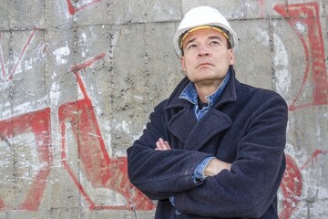 berlin, deutschland - bauarchitekt steht vor einer betonmauer und schaut aufmerksam