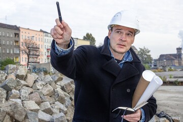 berlin, deutschland - architekt mit bauplänen gibt eine anweisung
