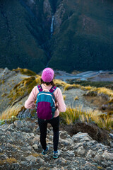 Brave and adventurous hiker girl admires powerful Devils Punchbowl Falls the breathtaking mountain scenery of Arthur&rsquo;s Pass and State Highway 73 from the Avalanche Peak trail