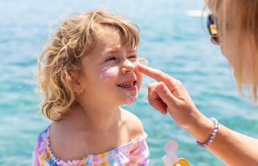 Fototapeta na wymiar The child has sunscreen on his face. Selective focus.