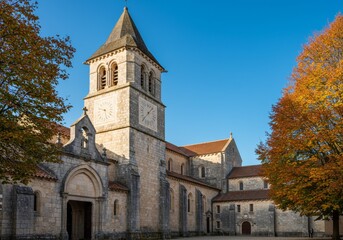 Fototapeta premium Ancient stone abbey with a clock tower under a clear autumn sky.