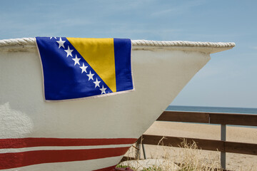 Beach Towel Draped Over A Boat with the flag of Bosnia and Herzegovina 3D Rendering