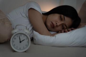 asian woman in bed late trying to sleep suffering insomnia, sleepless or scared in a nightmare,...