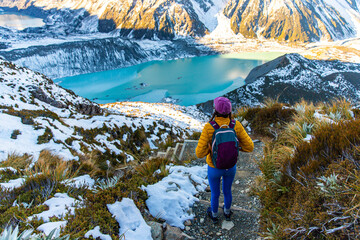 Brave hiker girl walks along alpine trail to Mueller Hut, admiring turquoise glacial tarns and stunning mountainous scenery, Aoraki Mount Cook National Park, Canterbury, South Island, New Zealand