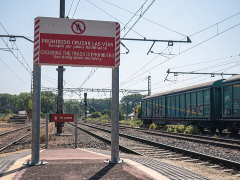 Toral de los Vados, Leon, Spain, 06-16-2025: Two red signs at the end of a train station platform indicating "No crossing the tracks" and "No passing" and the no pedestrian symbol