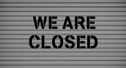 We are closed message with stencil font on a gray corrugated metal shutter door.