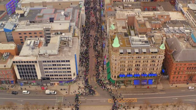 Aerial shot of St. Patrick's parade marching through Belfast streets