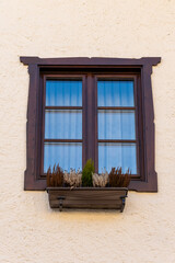 Classic facade with dark wood window - a harmonious combination of dark wood and beige walls in old...