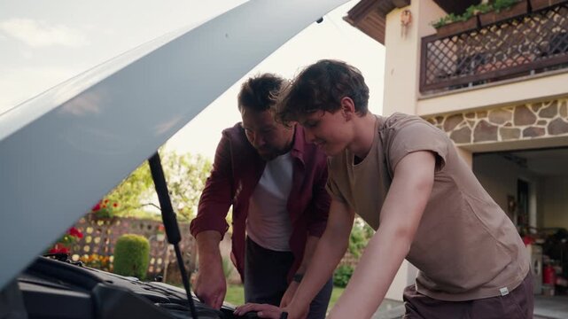 Father-son bonding moment while repairing a car.