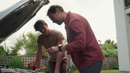 Father-son bonding moment while repairing a car.