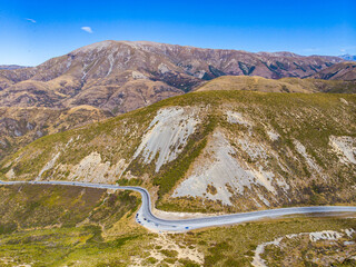 Aerial view of State Highway 73 winding through Porters Pass below Trig M, with views of Lake...