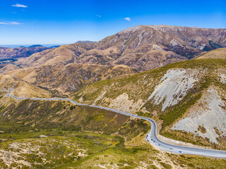 Aerial view of State Highway 73 winding through Porters Pass below Trig M, with views of Lake...
