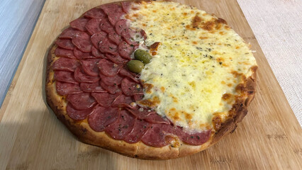 Delicious pepperoni and cheese pizza resting on wooden cutting board