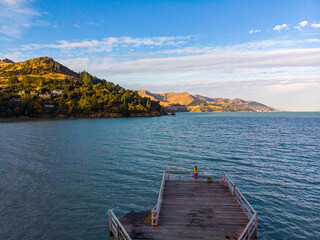 Aerial view of a girl standing at the end of Governors Bay jetty near Lyttelton, Banks Peninsula,...