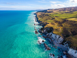 Aerial, drone view of towering white cliffs plunging into Pacific Ocean at remote Nape Nape beach near Christchurch, Canterbury, South Island, New Zealand.