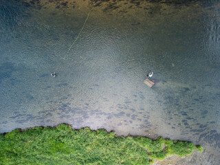two fly fishermen wading and fishing in the San River bed, Subcarpathian, Poland