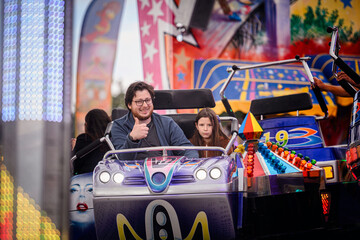 Man Gives Thumbs Up on Amusement Ride with Daughter