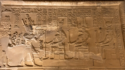 Wall relief at Kom Ombo shows Pharaoh worshipping Horus, Sobek, and Hathor.