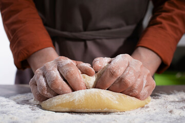 Baking concept. Caucasian female hands kneading the dough.
