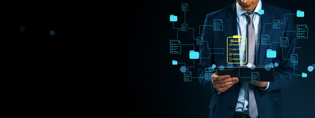 Businessman using tablet with digital document icons and data network structure on dark background for cloud document management concept.