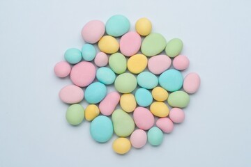 Pile of pastel colored oval shaped candies on a white background