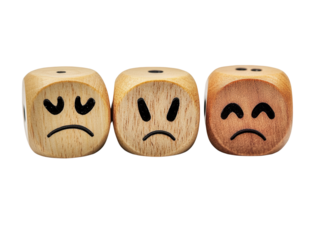 Wooden dice with sad, angry, and melancholic faces, perfect for illustrating emotions and moods.