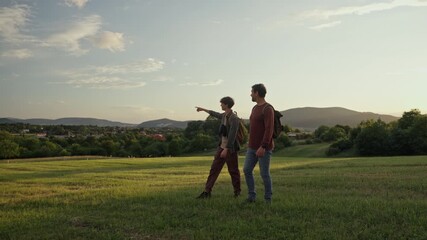 Dad and son walking through nature on hiking trail.