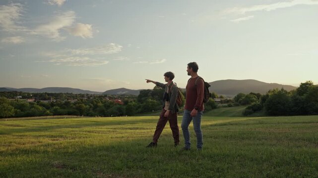 Dad and son walking through nature on hiking trail.