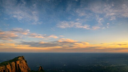 Golden hour paints a beautiful sky over the summer mountains, as the sun dips below the horizon