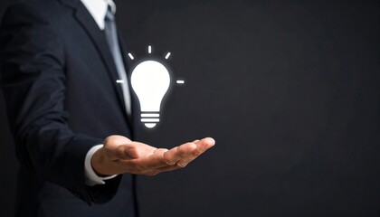 3D scene with a lightbulb-shaped idea icon floating above the hand of a blurred man in a suit