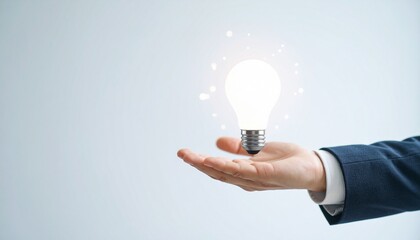 3D scene with a lightbulb-shaped idea icon floating above the hand of a blurred man in a suit