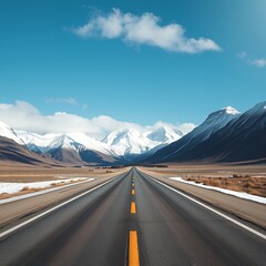 Naklejka premium Scenic mountain road leading to snow capped peaks under a clear blue sky