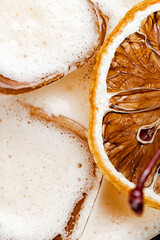 Closeup of a bubbly cocktail with foamy top and a slice of dried orange garnish. Perfect for...