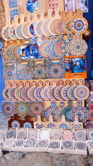 Display of colorful, ceramic trivets in front of a souvenir shop in the medina in Chefchaouen, Morocco