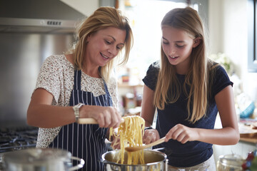 Mum and daughter preparing spaghetti in a cosy kitchen