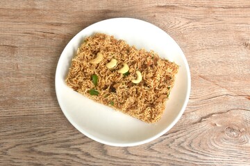 crispy fried thin rice noodles with coconut cream topping cashew nut and slice  seville orange on plate