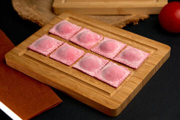 Delightful Pink Ravioli Arrangement on a Wooden Board Ready for Cooking or Serving, Showcasing Their Unique Color and Textural Appeal in a Culinary Presentation